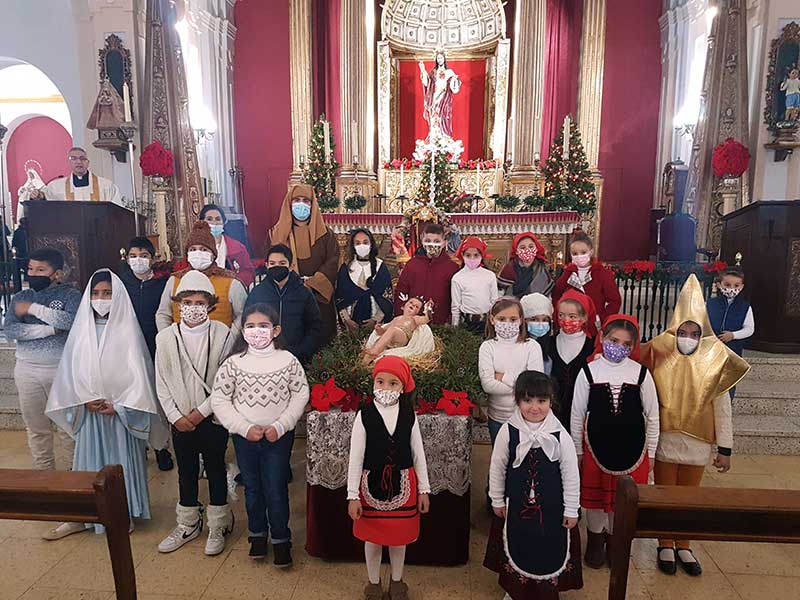 Nios y nias portan al Nio Jess